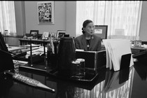 A photograph of Ruth Bader Ginsburg seated at a desk