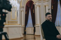 A color photograph of Zelensky seated and looking off camera during an interview