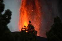 A bright orange burst of lava emerges from the ground