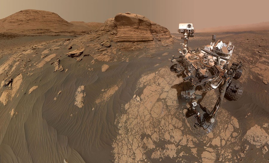 The Curiosity Mars rover is seen on the dusty surface of Mars.