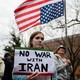 A protester holds a sign reading "No war with Iran."