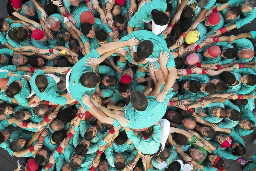 A top-down view of a crowd pushing and climbing, attempting to form a human tower.