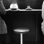 An empty stool in between two people at a dining establishment