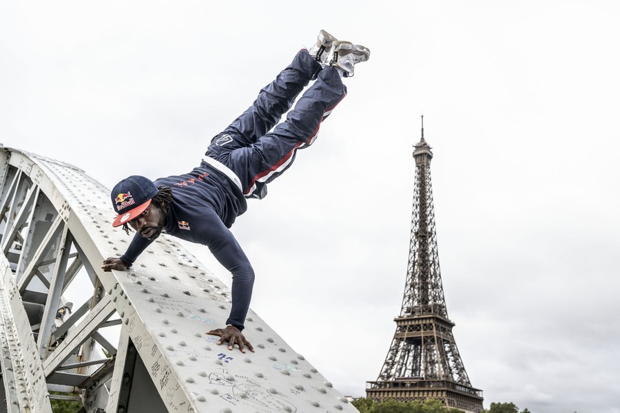 A dancer performs on part of a bridge, with the Eiffel Tower standing in the background.
