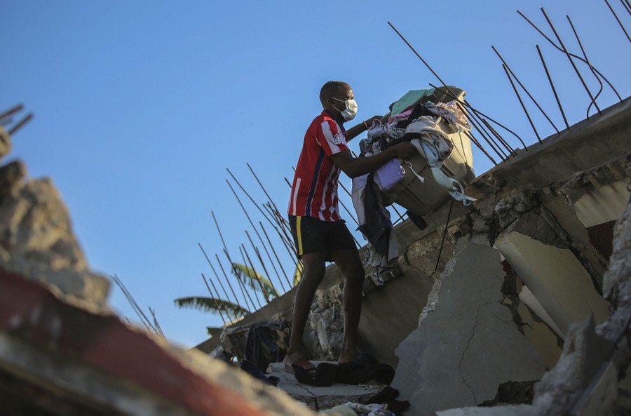 A man recovers belongings from his home that was destroyed by the earthquake in Les Cayes.