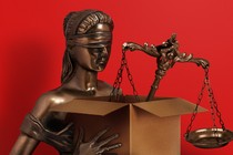 An illustration featuring a statue of a blindfolded woman (symbolizing justice) holding a cardboard box with a scale in it, suggesting she's been fired
