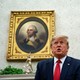 Trump sits in the Oval Office in front of a portrait of George Washington.