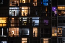 People in windows viewed through balconies