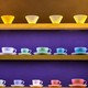 Rows of colorful coffee cups and glasses on shelves