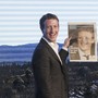 Facebook's Mark Zuckerberg holds a newspaper with a picture of him on it.