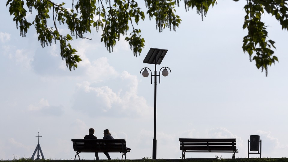 Two people on a bench under a tree