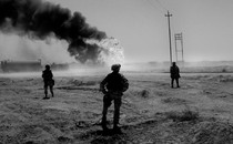 An image of U.S. soldiers standing guard over an Iraqi oilfield, 2003