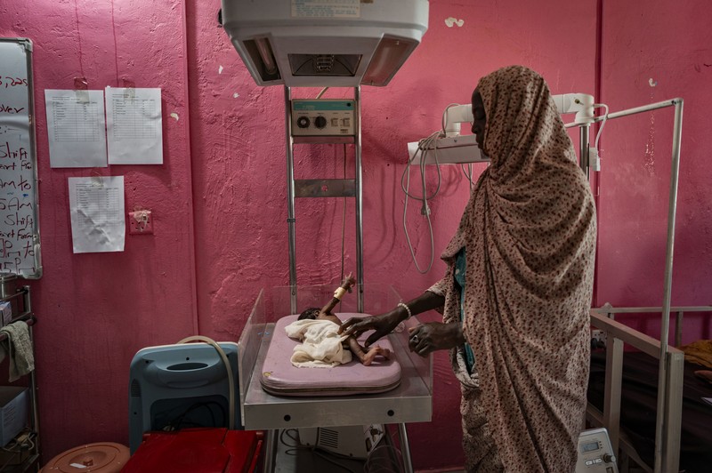 A woman with a baby in a hospital bed