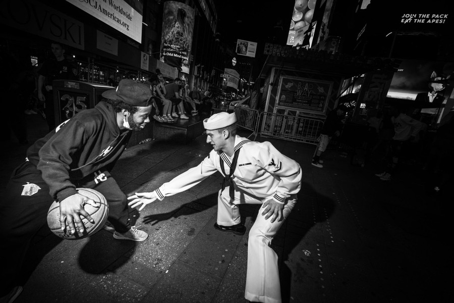 Two men play with a basketball on a street in Times Square.