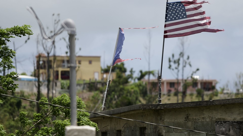 The U.S. flag, next to a damaged Puerto Rican flag, flies in the municipality of Yabucoa.