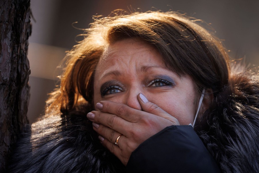 A person looks upset, holding one hand over their mouth.