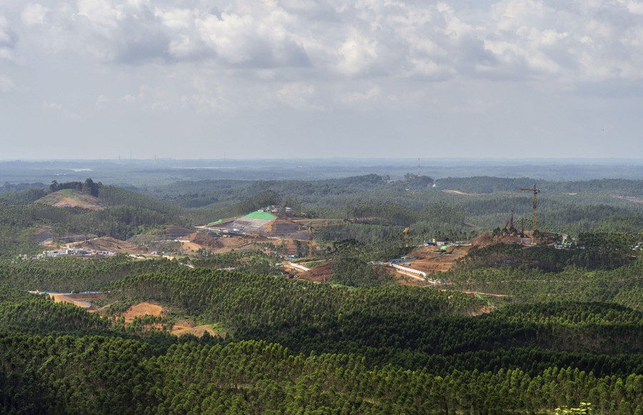 An aerial view of hills dotted with several large construction sites