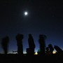 Silhouettes of stargazers against a night sky