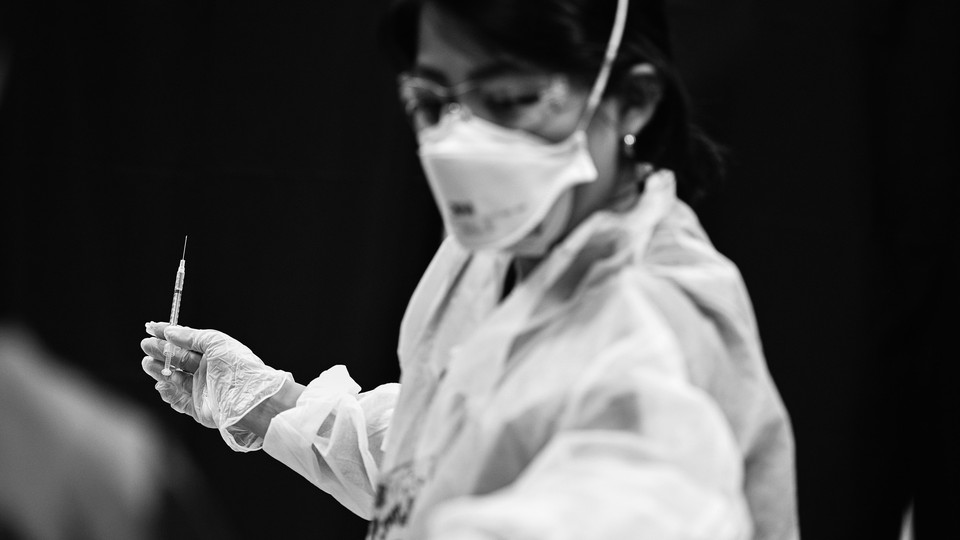 A nurse holding a vaccine needle
