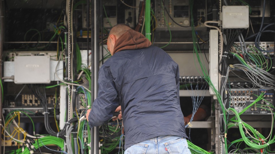 A technician arranges wiring ahead of a public event in Rome, Italy.