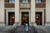 A student walks up the steps of Harvard University