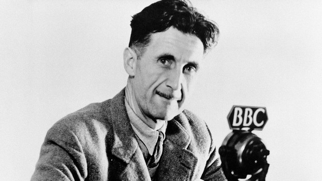 A black and white portrait of George Orwell in 1943 in front of a microphone with a "BBC" tag