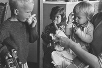 Black-and-white photo of children blowing their noses