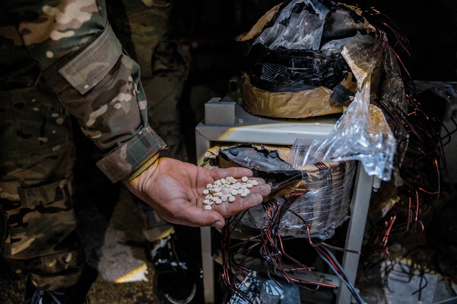 A soldier holding a handful of captagon pills
