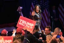 Rep. Elise Stefanik waves to the crowd, and a supporter holds up a "Trump Will Fix It" sign