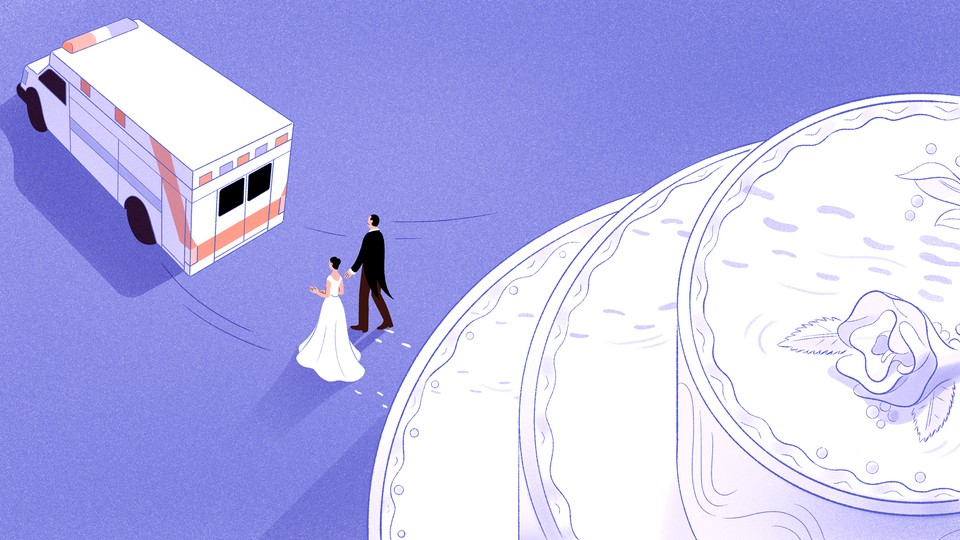 A man and a woman walk away from a cake and toward an ambulance.