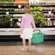 A young girl looks at the produce aisle in a grocery store.