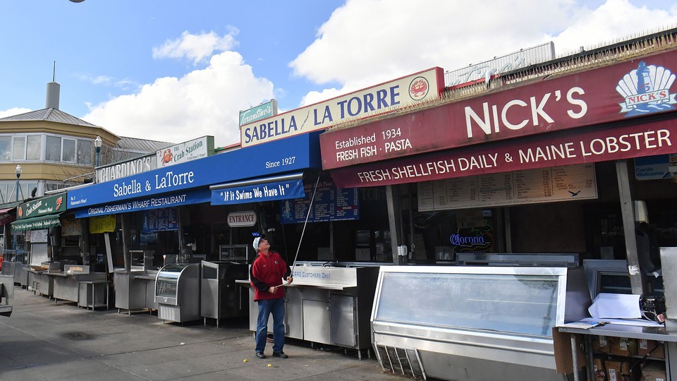 At Fisherman's Wharf in San Francisco, a man closes his shop as the Bay Area prepares for a lockdown effort to slow the spread of coronavirus.