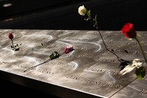 A part of the 9/11 memorial, with flowers over it