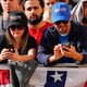 Bernie Sanders supporters look down at their phones during a rally.