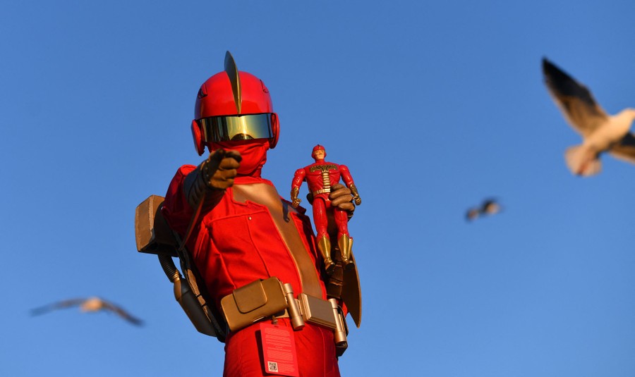 A person in costume poses, pointing toward the photographer.