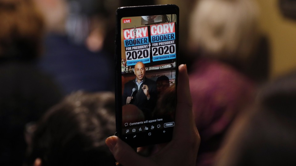 Cory Booker, seen through a cellphone, speaking in Marshalltown, Iowa
