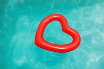 A red heart-shaped floaty in a blue pool