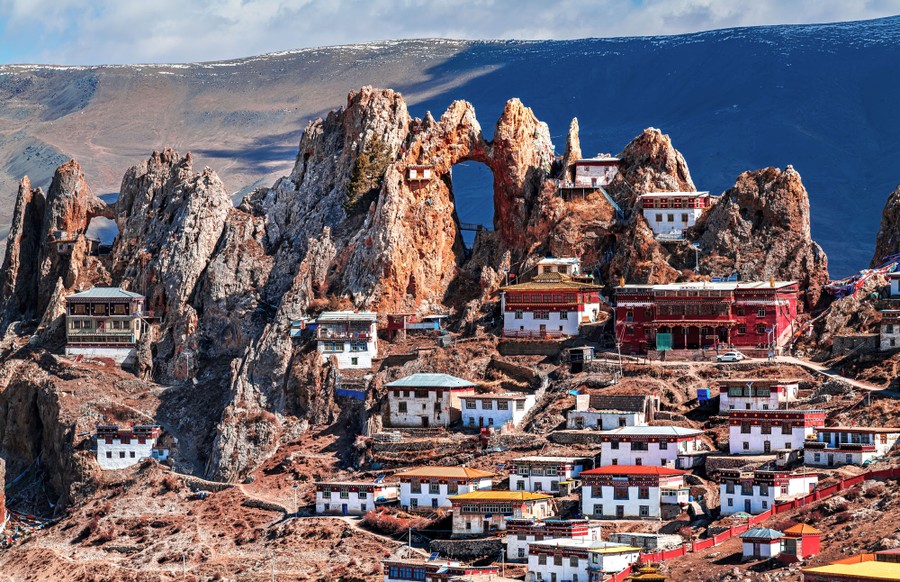 A couple of dozen medium-to-small buildings sit clustered on the slopes of steep rock formations and arches.