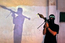 A masked member of Hamas holds a weapon in 2013.