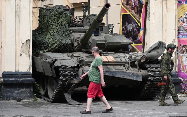 A civilian walks past a tank