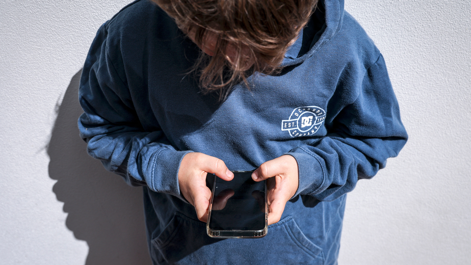 A young person holding a phone