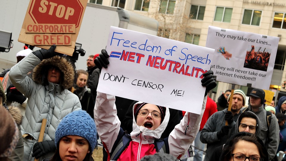 A protestor holding a sign that reads "Freedom of Speech = Net Neutrality; Don't censor me!"