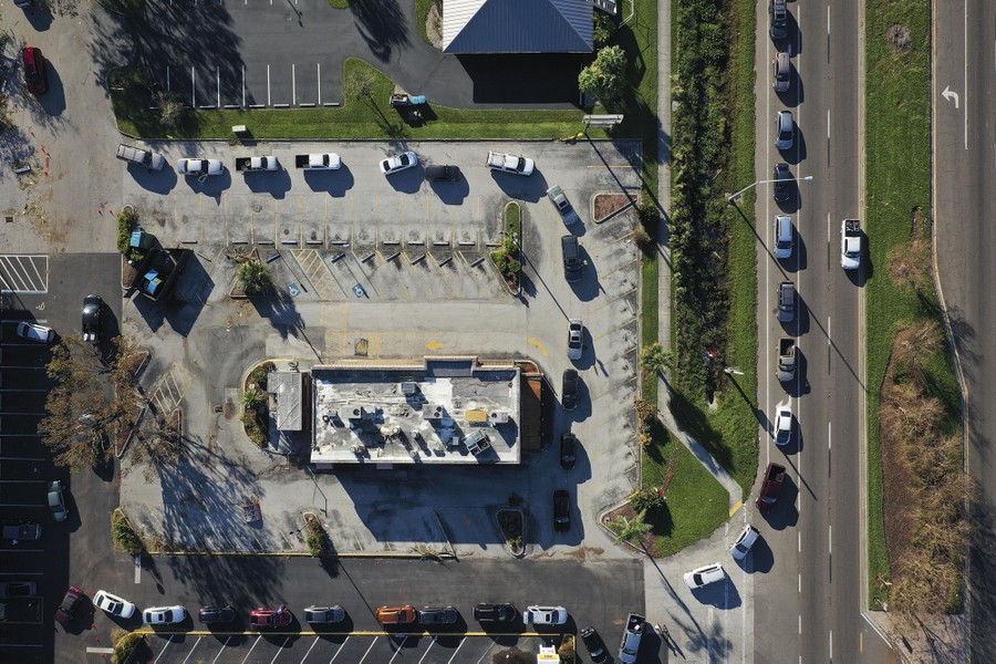 An aerial view of many cars lined up outside a parking lot