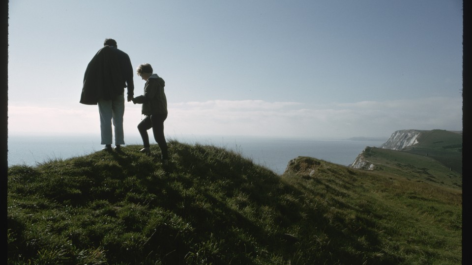 A man and a child standing atop a mountain