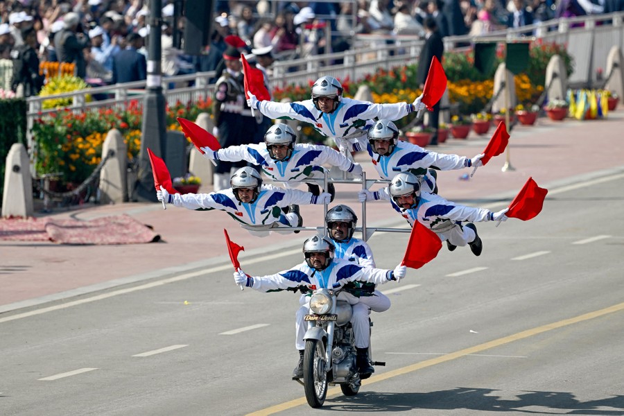A motorcycle stunt team made up of seven members rides a complicated apparatus attached to a single motorcycle.