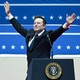 Elon Musk raises his arms in front of the presidential podium