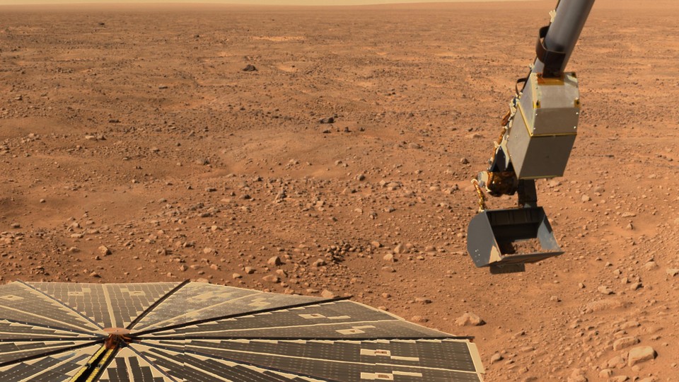 The robotic arm on the Phoenix Mars Lander picking up a scoop of soil from the surface of Mars