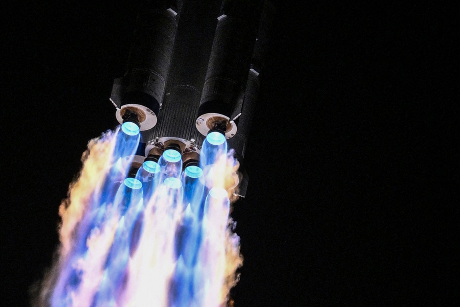 Flames erupt from engines on a rocket as it launches.
