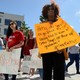 Protesters gather at a university with signs protesting Betsy DeVos and her plans for campus sexual-assault policies.