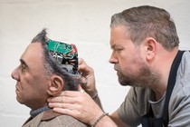 A human fixes a human-looking robot